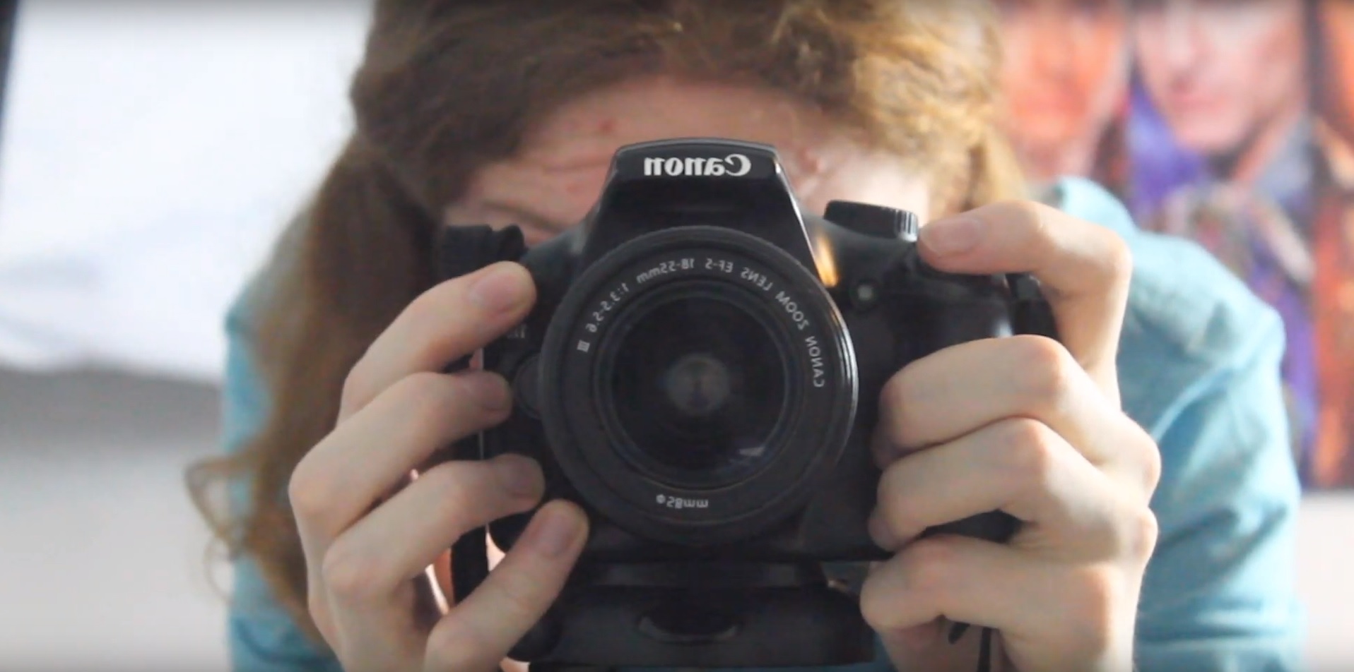 a hand holding a small camera