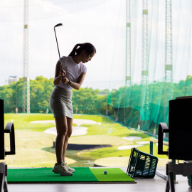 woman swinging golf club