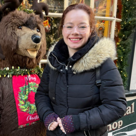 girl smiling infront of toy bear