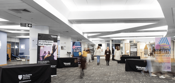 large room with blurred people walking though