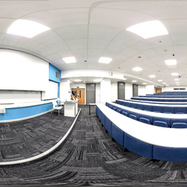 Fisheye photograph of tiered lecture theatre with projector screen and PC. 