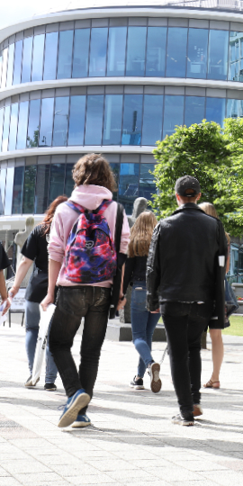 university students with backpacks walking on campus road