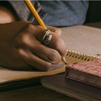 Image of a hand writing with a pencil