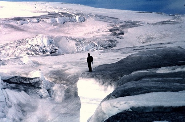 Man standing on ice cliff in antarctica