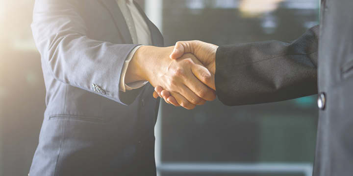 Two people in suits shaking hands