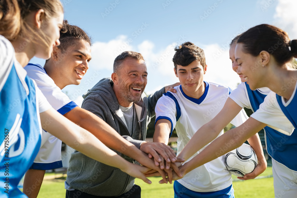 Teenagers and Coach in a huddle before a game