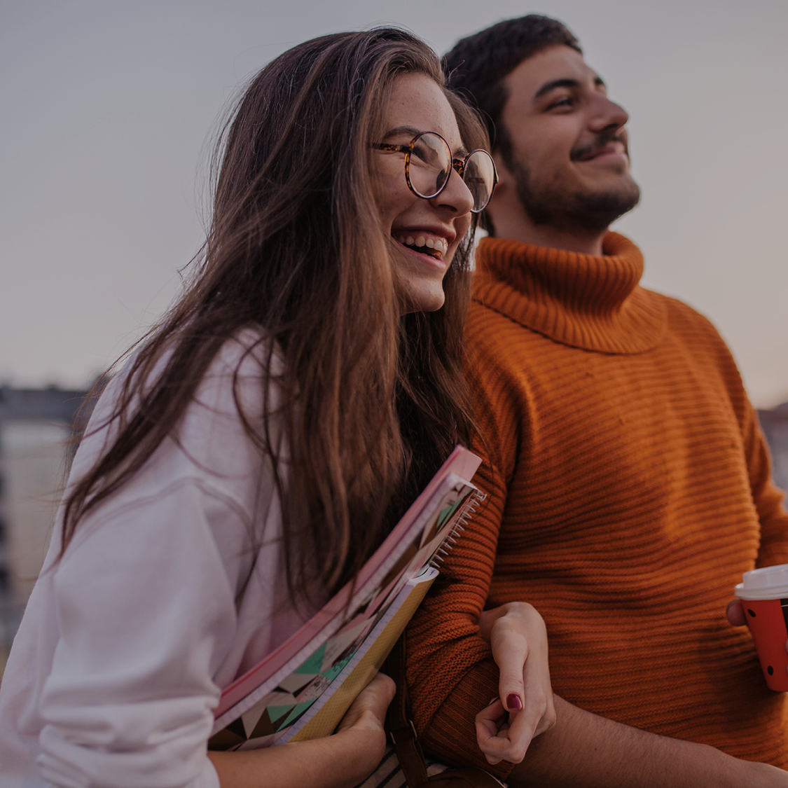 Male and Female Students Walking and holding books