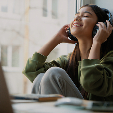 Young Woman sitting relaxed with headphones on