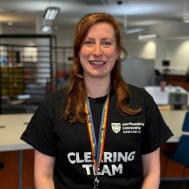 A woman wearing a black t shirt with the Northumbria logo on it.