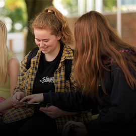 two female students staring at a booklet