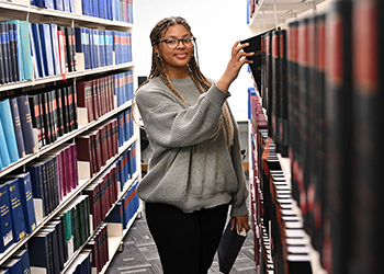 Student getting book from shelf