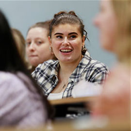 Cropped image of smiling female student sitting in class seminar setting