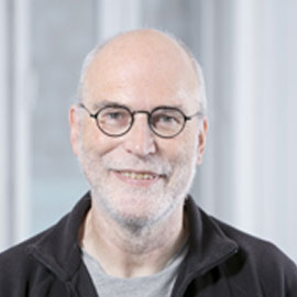 a man wearing glasses and smiling at the camera