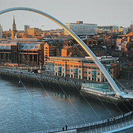 a bridge over water with a city in the background