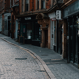 a narrow city street with buildings on the side of a road