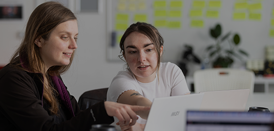 two students working together on a laptop