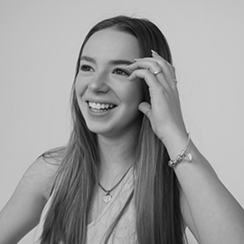 Black and white image of woman smiling with her hand to her face