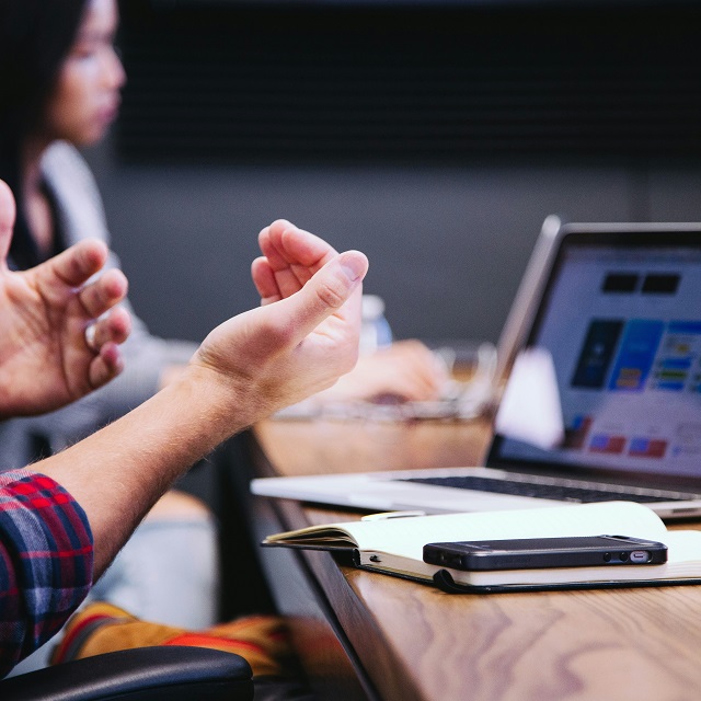 man using hands to discuss with colleagues