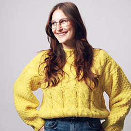 student with yellow jumper and hands on hips