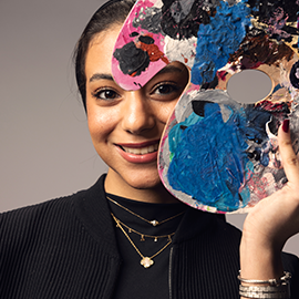 student holding a arts colour palette