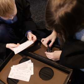 two people trying to solve a riddle, holding cards